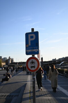Public parking sign on a sunny day in a modern European city. Blue parking symbol with restriction plate, urban transport and travel infrastructure concept. Street navigation and transportation regula