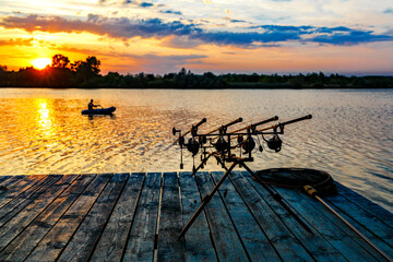 Carpfishing session at the Lake.Carp fishing rods standing on special tripods.Scenic landscape...