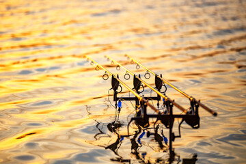 Carpfishing session at the Lake.Carp fishing rods standing on special tripods.Scenic landscape...