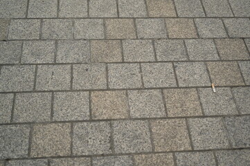 Granite pavement texture with geometric stone pattern. Urban background of grey and beige paving blocks — natural stone surface for architecture, design, and construction concepts.