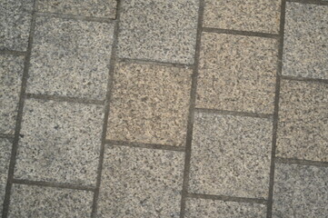 Granite pavement texture with geometric stone pattern. Urban background of grey and beige paving blocks — natural stone surface for architecture, design, and construction concepts.
