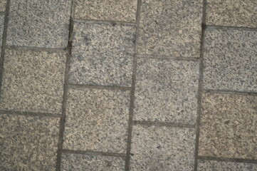 Granite pavement texture with geometric stone pattern. Urban background of grey and beige paving blocks — natural stone surface for architecture, design, and construction concepts.