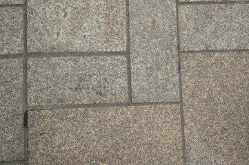 Granite pavement texture with geometric stone pattern. Urban background of grey and beige paving blocks — natural stone surface for architecture, design, and construction concepts.