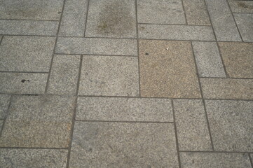 Granite pavement texture with geometric stone pattern. Urban background of grey and beige paving blocks — natural stone surface for architecture, design, and construction concepts.