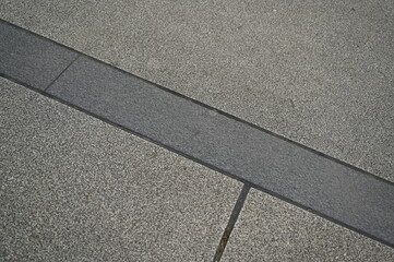 Fototapeta premium Stone pavement with rectangular tiles. Close-up of urban sidewalk surface with textured stone blocks