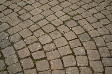 Опис (Description):
Old cobblestone pavement with irregular stone pattern. Historic European street texture with weathered stones and moss between the gaps