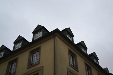 Corner of an old European building with mansard roof and windows. Historic architecture typical for Luxembourg or France. Travel and city background.