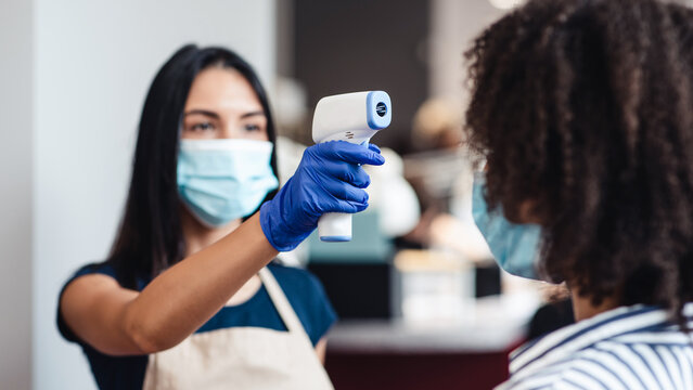 Body Temperature Measurement. Female beauty master checking client using infrared thermometer