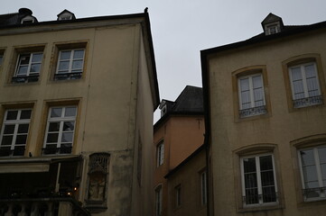 Narrow street with historic yellow buildings in Luxembourg City. Traditional European architecture with windows and tiled roofs — quiet atmosphere of the old town.