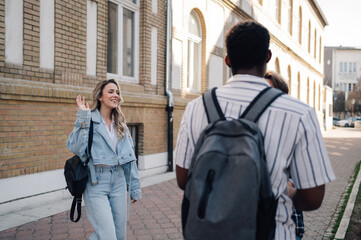 Young woman waving to friends on city street