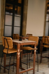Cozy cafe interior with wooden tables and chairs. Vintage restaurant furniture in warm tones, ideal for hospitality, lifestyle, and design themes