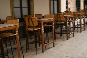 Cozy cafe interior with wooden tables and chairs. Vintage restaurant furniture in warm tones, ideal for hospitality, lifestyle, and design themes