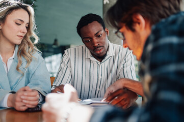 Startup team reading documents during business meeting in cafe