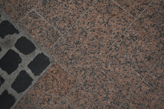 Modern sidewalk tiles with decorative stone and concrete textures. Geometric patterns and contrasting colors create a clean, urban street design. Ideal background for architectural, construction, or c