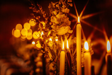 Dozens of glowing candles cast a golden ambiance over a beautifully decorated dinner table with...