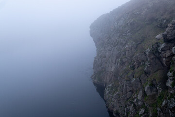 Rocky river bank shrouded in fog