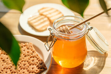 Honey Jar and Dipper on a Wooden Table With Bread and Cookies, Surrounded by Greenery. Ideal for Cafes and Health Food