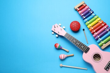 Flat lay composition with different toy musical instruments on light blue background. Space for text