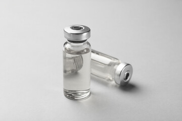 Hepatitis vaccine in glass vials on grey background, closeup