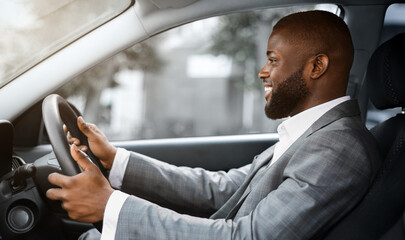 Side view of joyful african american young man driver looking at the road and smiling, copy space....