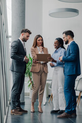 Business people discussing work in modern office using clipboard