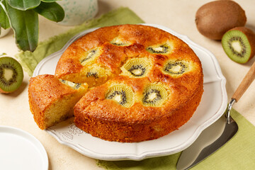 Homemade fruit kiwi cake, sweet pie. Beige table surface.