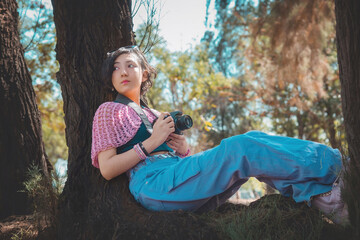 Young woman photographer holding a camera poses for the camera, photographer's day concept, has plenty of room to write.