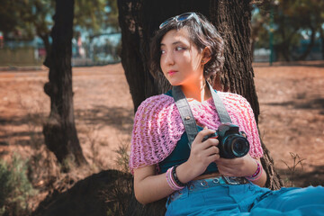 Young woman photographer holding a camera poses for the camera, photographer's day concept, has plenty of room to write.
