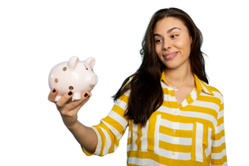 Young woman holding piggy bank and looking at her savings with satisfaction, isolated on transparent background