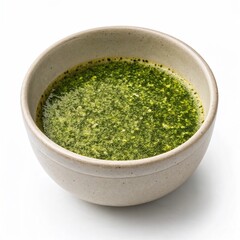 bowl of green pesto sauce on white background