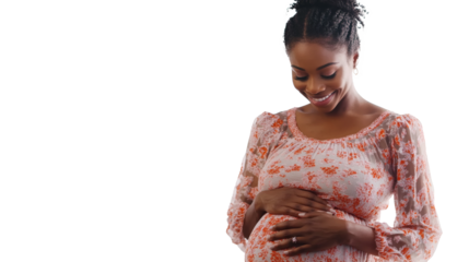 Glowing pregnant woman in floral dress, tenderly cradling her belly with a serene, joyful expression on her face.