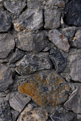 Textured stone wall adds rustic charm to an ancient building in a serene countryside setting during the golden hour of evening
