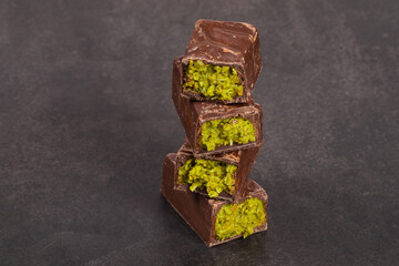 Modern Dubai chocolate bar with crispy kataifi and pistachio paste. Dark background. Close up