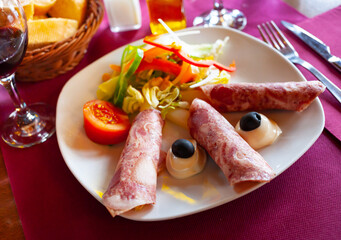 Delicious ham rolls with white asparagus garnished with hollandaise sauce and greens