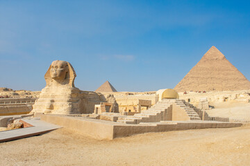 Great Sphinx and Great Pyramid of Cheops, Cairo, Egypt. Ancient statue of Sphinx, mythical creature with head of man and body of a lion, Giza pyramid complex (Giza Necropolis)