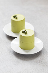 Modern Pistachio cream pudding, cylindrical Panna Cotta. light background. 
