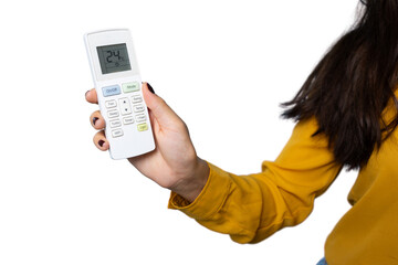 Woman controlling air conditioner remote, lowering temperature setting against transparent backdrop