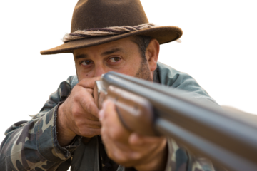 Hunting period, autumn season open. A hunter with a gun in his hands in hunting clothes in the autumn forest in search of a trophy. A man stands with weapons and hunting dogs tracking down the game.