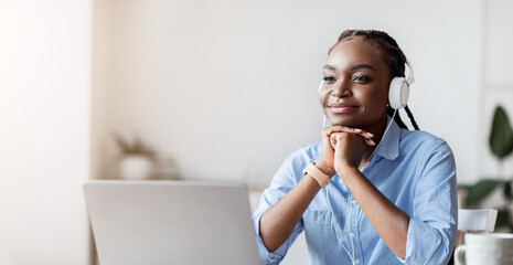 Break At Work. Relaxed African American Female Employee Listening Music In Headphones At Workplace In Office, Sitting At Desk With Laptop Computer And Looking Away, Resting Chin On Hands, Copy Space