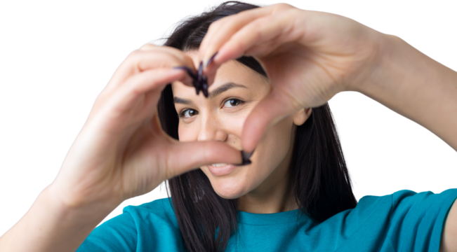 Portrait of a smiling young woman showing heart gesture with her fingers isolated over grey background
