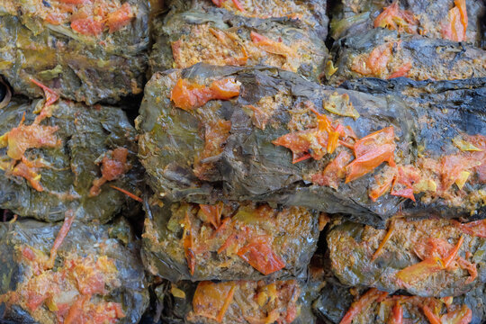 Traditional Indonesian buntil made from leafy vegetable wraps filled with seasoned grated coconut. Authentic local cuisine concept for homemade food and cultural dishes
