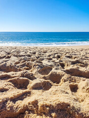 Serene beach scene featuring golden sand meeting the turquoise sea under a clear blue sky. Perfect for travel, vacation, and relaxation concepts. A calming coastal view.