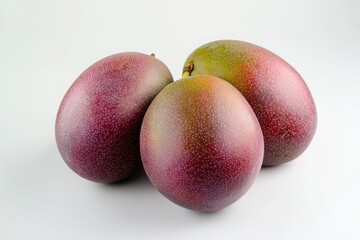 Fototapeta premium Close up of three mangos with red and green skin on white background