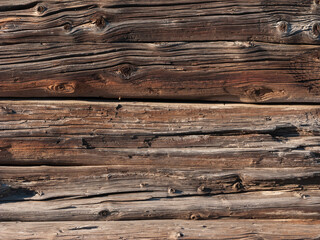 Fragment of old half-rotten logs of the wall of a wooden house, useful as background