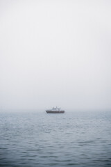 Boats in the misty sea on a calm morning.