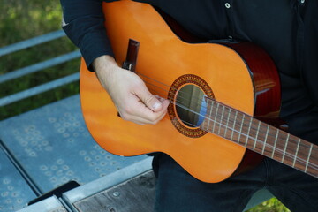 Man Tunes Guitar With Tuning Fork Outside