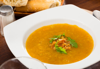 Dietary cream soup of vegetables garnished with caramelized onion and fresh arugula ..