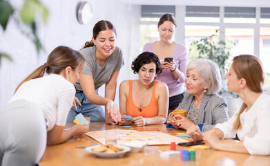 Group of students of different years play a board game with passion