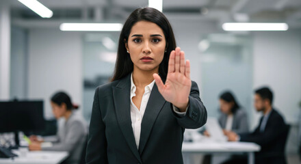 Woman shows stop gesture with her hand. Concept of protection against workplace harassment and violence. Prevention of abuse. Female business professional asks to stop, say no