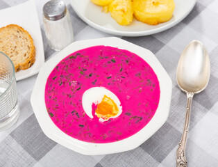 Cold beetroot soup, cold borscht or cholodnik, served in bowl on table.